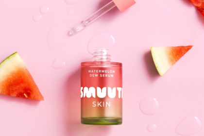 Smuuti Skin Watermelon Dew Serum flaska omgiven av färska vattenmelonklyftor på rosa bakgrund